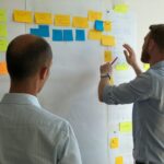 man in gray shirt facing sticky notes