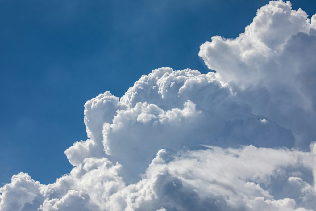 a plane flying through a cloud filled sky